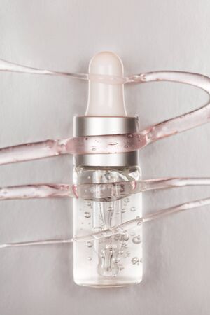 Bottle with hyaluronic acid on silver background. Concept of modern beauty. Flat lay style.の写真素材