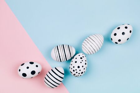Many easter eggs on trendy pink pastel background. Eggs are hand-drawn. Flat lay style.の写真素材