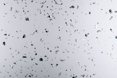 Silver falling confetti on metallic backdrop. Festive and party concept.の写真素材