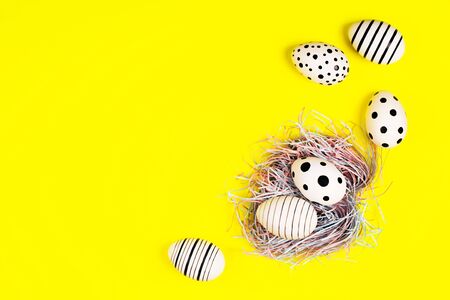 Banner with hand-painted eggs and nest on bright yellow background. Easter concept.の写真素材