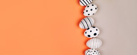 Easter eggs dotted on multicolored background. Festive concept. Flat lay styleの写真素材