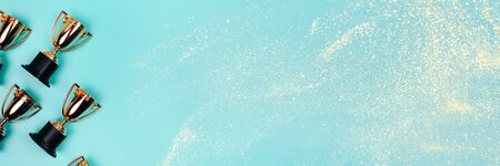 Frame made of winner cups on a pastel blue background with copy space. Flat lay style.の写真素材