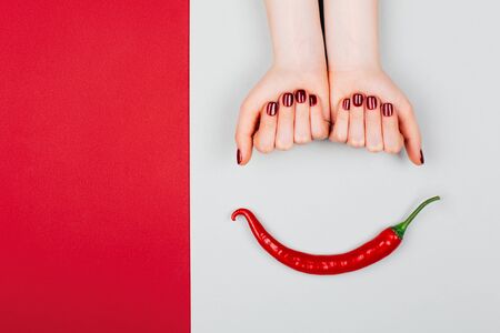 Red beautiful manicure on red and grey stylish background with copyspace. Flat lay style.の写真素材