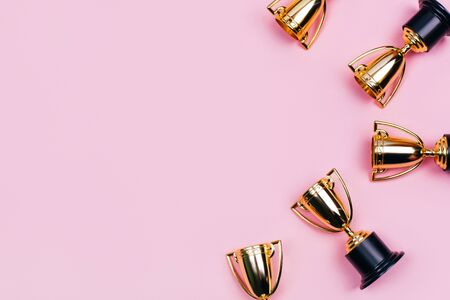 Winner cups on a pink background. Banner with a place for text. Flat lay style.の写真素材