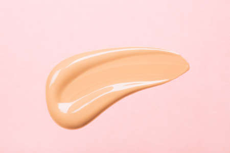 Smear of foundation on pink background. Beautiful advertising glance photo. Cosmetics concept isolated on whiteの写真素材
