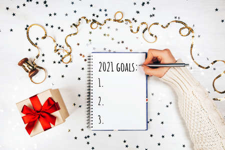 Holiday decorations and notebook with new year resolutions liston white rustic table, flat lay style. Planning concept for 2021の写真素材