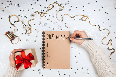 Notebook with new year resolutions list on white rustic table, flat lay style. Planning concept for 2021の写真素材