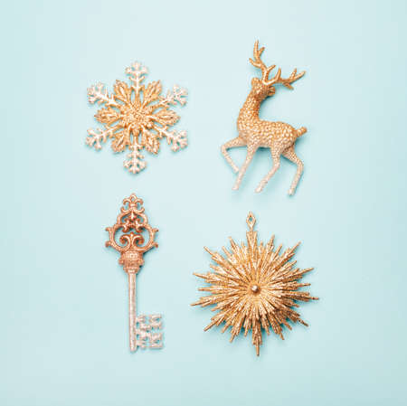 Accurate rows of four golden beautiful of Christmas ornaments on pastel blue background. Square shape for social mediaの写真素材
