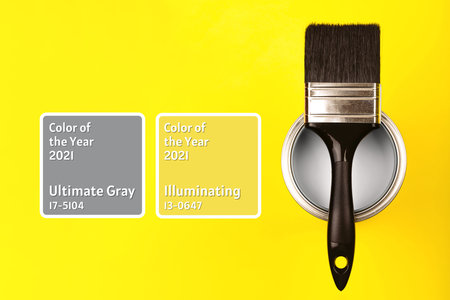 Demonstrating colors of year 2021 - Gray and Yellow. Brush with wooden handle on open can with frames. Renovation concept.の写真素材