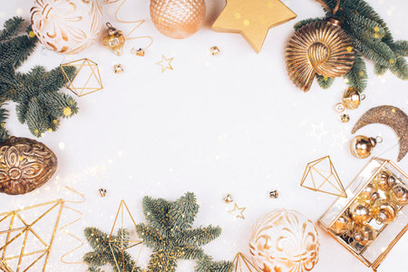Christmas decorations on white background. Fir tree, golden toys, sparkles and lights. Place for your textの写真素材