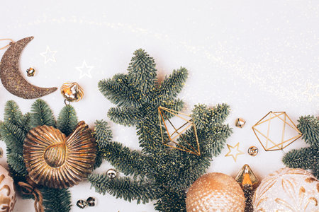 Christmas decorations on white background. Fir tree, golden toys, sparkles and lights. Place for your textの写真素材