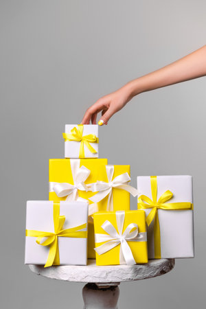 Demonstrating trendy colors of year 2021 - Gray and Yellow. Yellow gift with white ribbonの写真素材