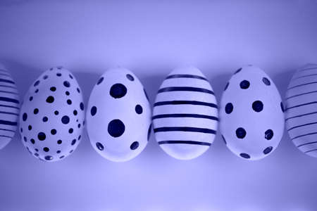 Different graphic hand-painted eggs in Proton Purple neon light.の写真素材