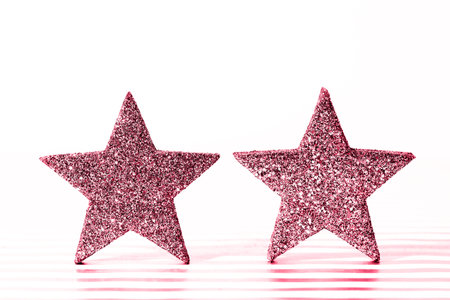 Textured glittering red stars on white background. Demonstrating Viva Magenta - trendy color of the year 2023の写真素材