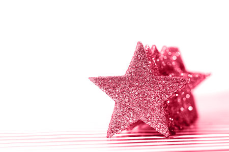 Textured glittering red stars on white background. Demonstrating Viva Magenta - trendy color of the year 2023の写真素材