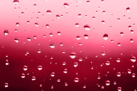 Beautful rain drops on the window. red gradient. Demonstrating Viva Magenta - trendy color of the year 2023の写真素材