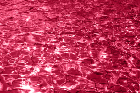 Red transparent pool water. Demonstrating Viva Magenta - trendy color of the year 2023の写真素材