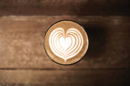 Heart-shaped latte art on coffee table viewed from aboveの写真素材