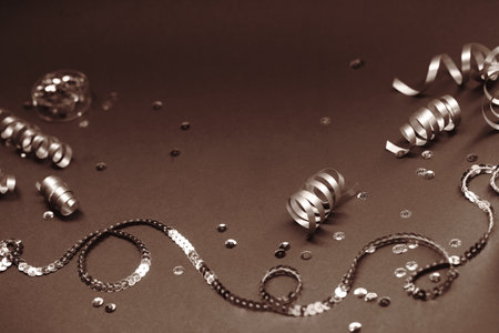 Festive ribbons and sequins on a moody brown background for celebrationの写真素材
