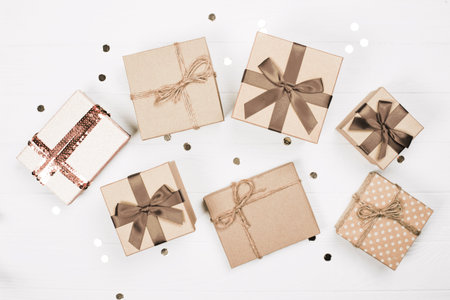 Assorted gift boxes with elegant ribbons arranged on a white wooden table