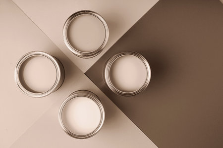 Four open paint cans on a brown and cream geometric backgroundの写真素材