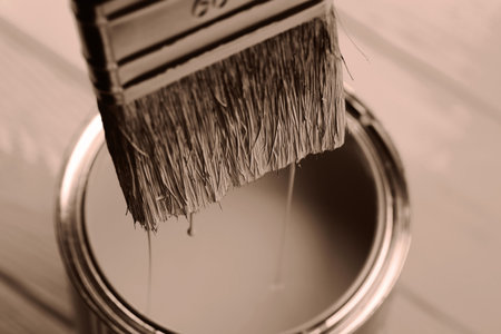 Close-up of paintbrush dipped in a can on wooden surfaceの写真素材