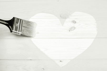 Painting heart shape on wooden background with brush.の写真素材