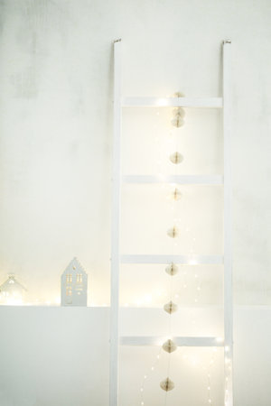 Minimalist christmas home decor with festive lights ladder.の写真素材