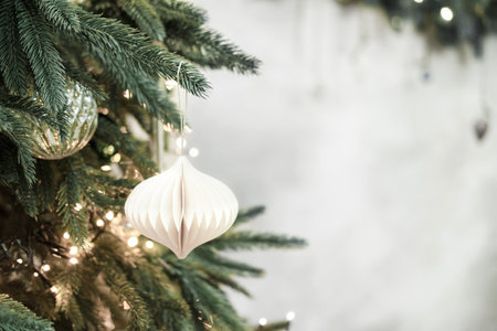 Christmas tree decorating with a white paper ornament.の写真素材