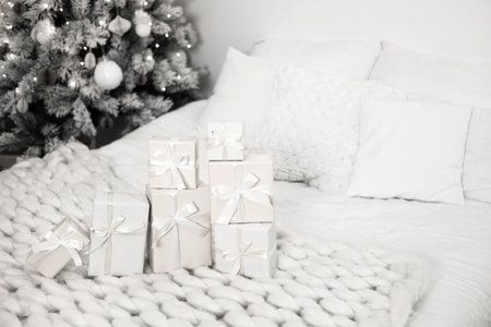 Christmas presents lying on cozy white bed.の写真素材