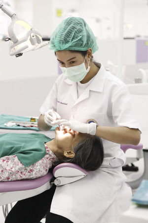 Rama dental hospital, Bangkok, Thailand - Feb 27, 2013   Dentist woking on and old patient in Rama Hospital のeditorial素材