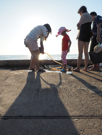 Koh Samae sarn - Pattaya, Thailand - December 30, 2015 : women and kid wash their foot with back litのeditorial素材