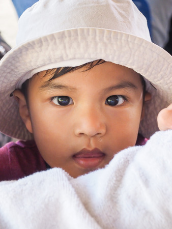 Koh Samae sarn - Pattaya, Thailand - December 30, 2015 : Thai's Cute male wearing hat and look at the cameraのeditorial素材