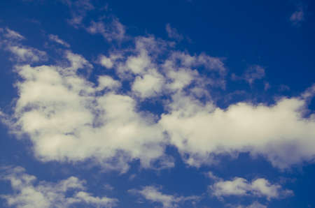 cumulus clouds float across the blue skyの写真素材