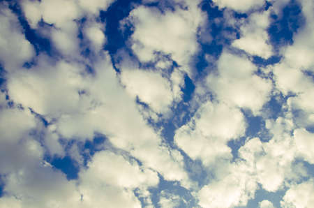 cumulus clouds float across the blue sky