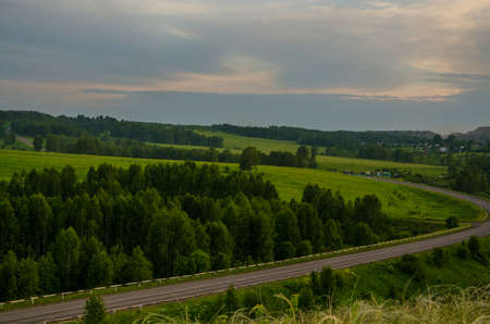 Summer crimson sunset. sky crimson. maroon clouds on sunset. green carpet at sunset.の写真素材