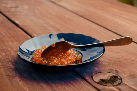 red caviar in a blue plate. wood planksの写真素材