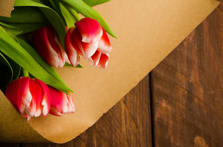 red white tulips on wooden boards. Bouquet of tulips in kraft paperの写真素材
