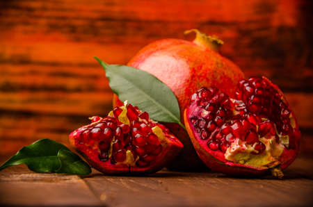 ripe pomegranate seeds. fresh juicy leaves. juicy pomegranate on wooden boards.cut into pieces of...