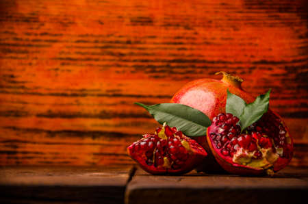 ripe pomegranate seeds. fresh juicy leaves. juicy pomegranate on wooden boards.cut into pieces of ripe pomegranate. the pomegranate is ripe.の写真素材