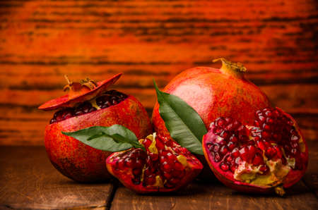 ripe pomegranate seeds. fresh juicy leaves. juicy pomegranate on wooden boards.cut into pieces of ripe pomegranate. the pomegranate is ripe.の写真素材
