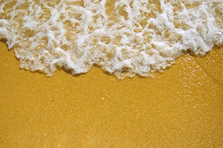 White wave on a sandy beach.の写真素材