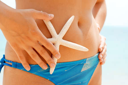 Woman with starfish on the beach.の写真素材