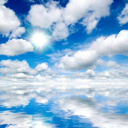sky with clouds and sun in water reflectionの写真素材