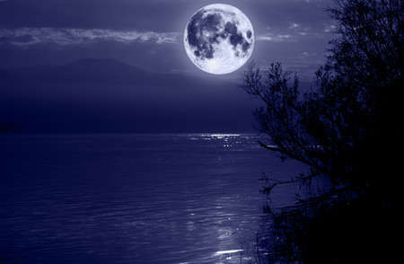 big blue moon over waterの写真素材