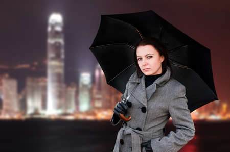 Woman with umbrella in night city.の写真素材