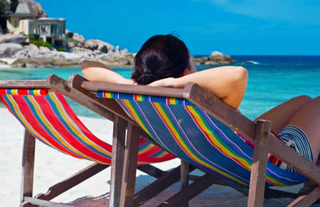 Woman  in desk chair on the beach.の写真素材