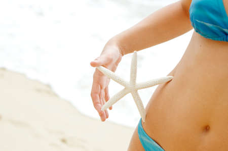Woman with starfish on the beach.の写真素材