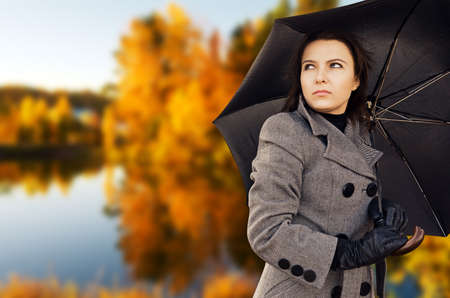 Woman with umbrella in autumn park.の写真素材