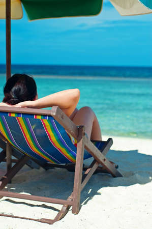Woman  in desk chair on the beach.の写真素材